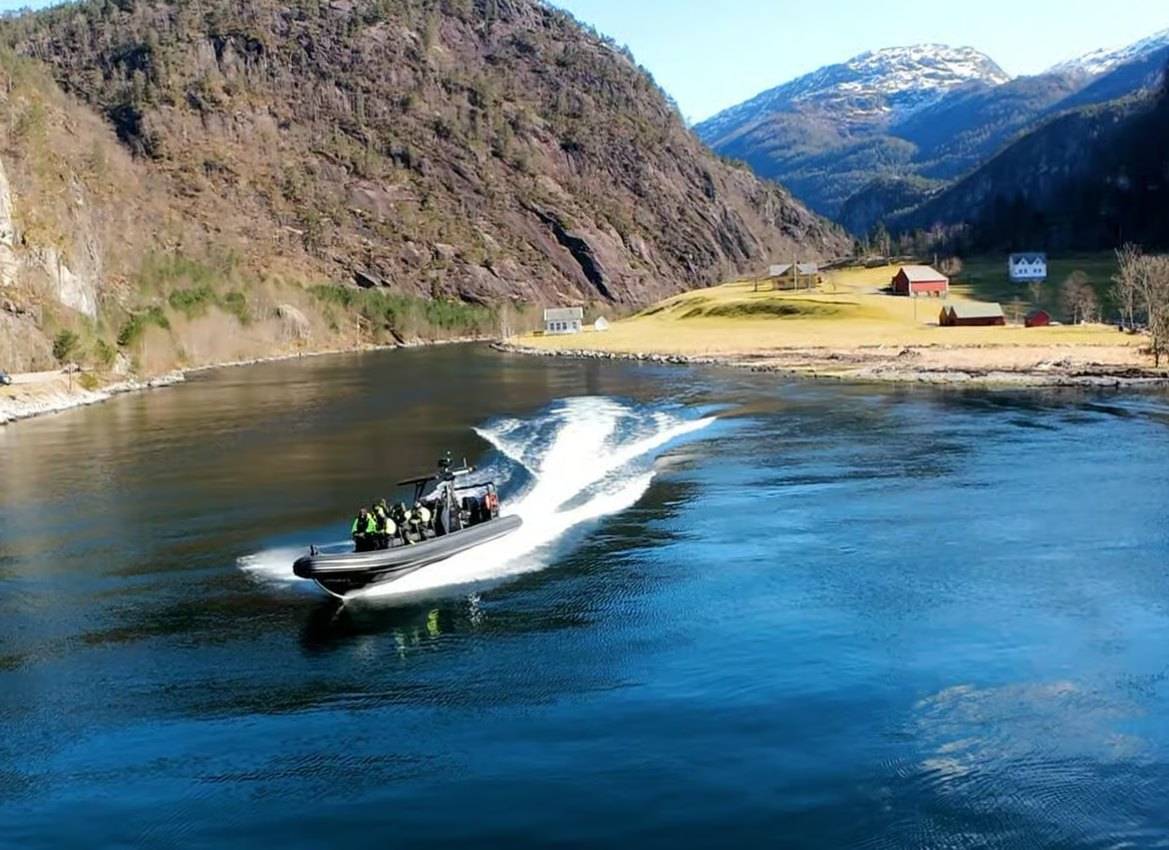 Premium RIB boat speeding through the Osterfjord near Mostraumen.