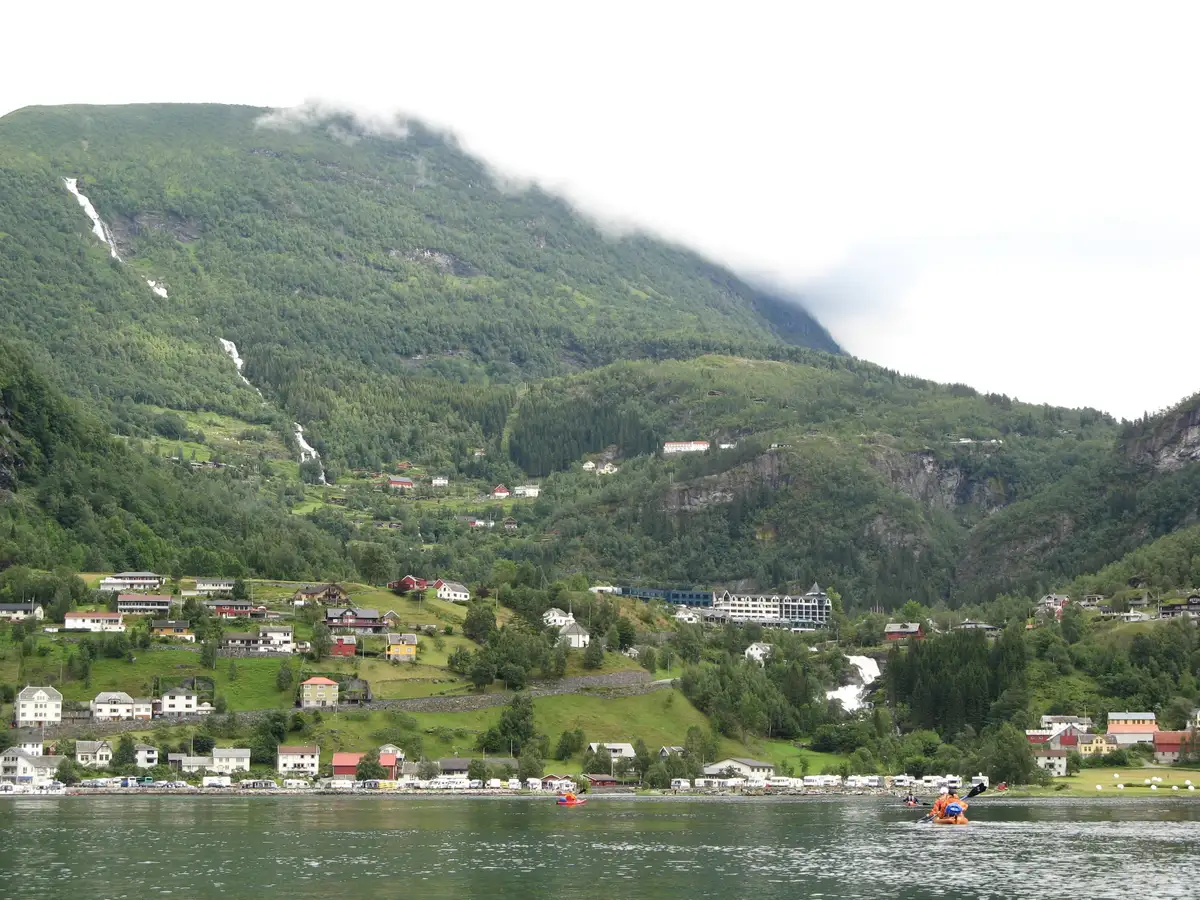 The village of Geiranger on the waterfront at the head of the Geirangerfjord, with mountains rising behind.
