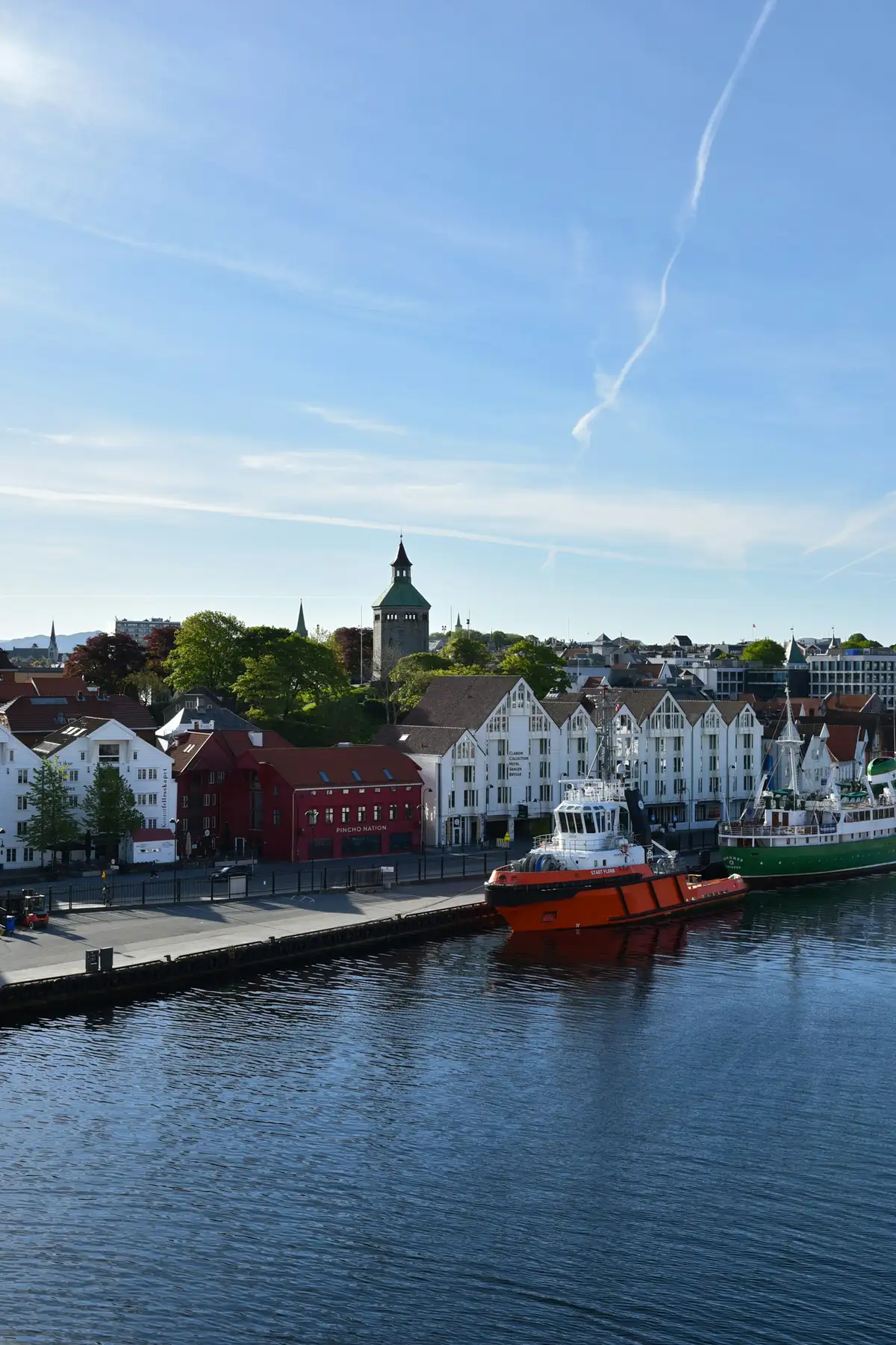 Stavanger harbour at Vågen with boats, waterfront warehouses, and Valberg Tower.